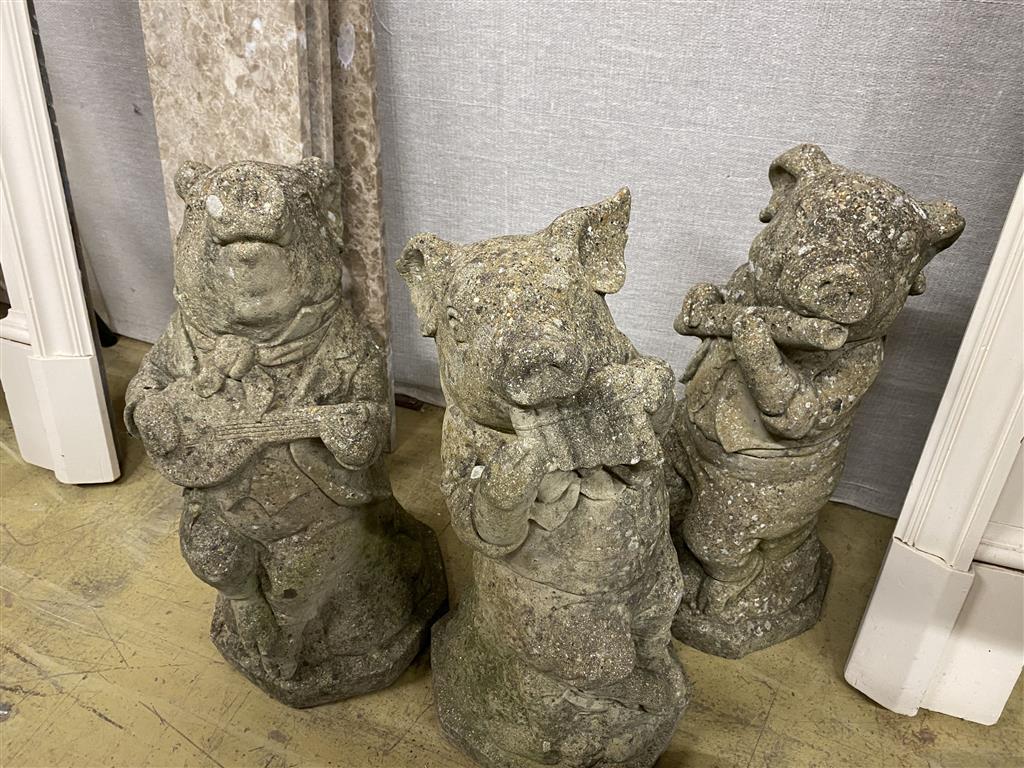 Four reconstituted stone garden ornaments, modelled as pigs, largest 60cm high